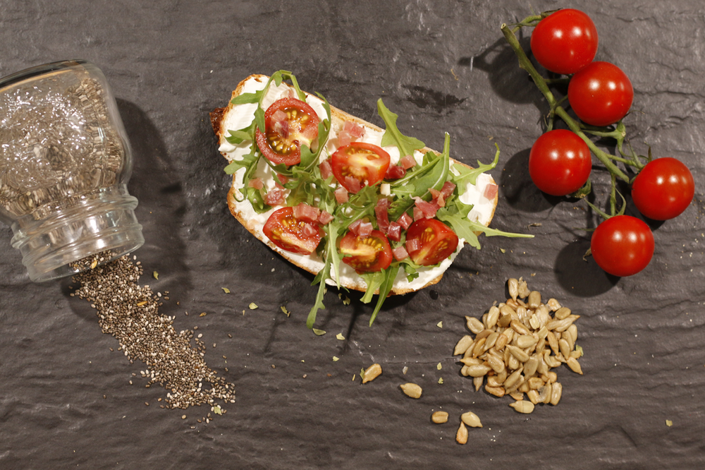 Tostadas de queso, tomatitos,jamón y rúcula