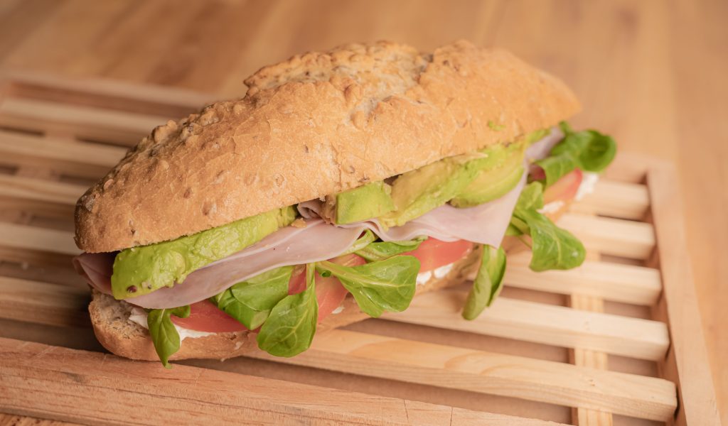 Bocadillo de aguacate, jamón dulce, lechuga, tomate y queso