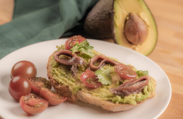 Recetas de tostas para cenar: Tosta de guacamole, tomate y anchoas